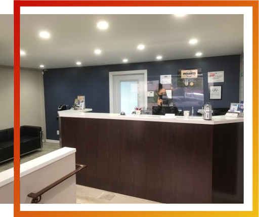 A hotel lobby with a person standing at the front desk.